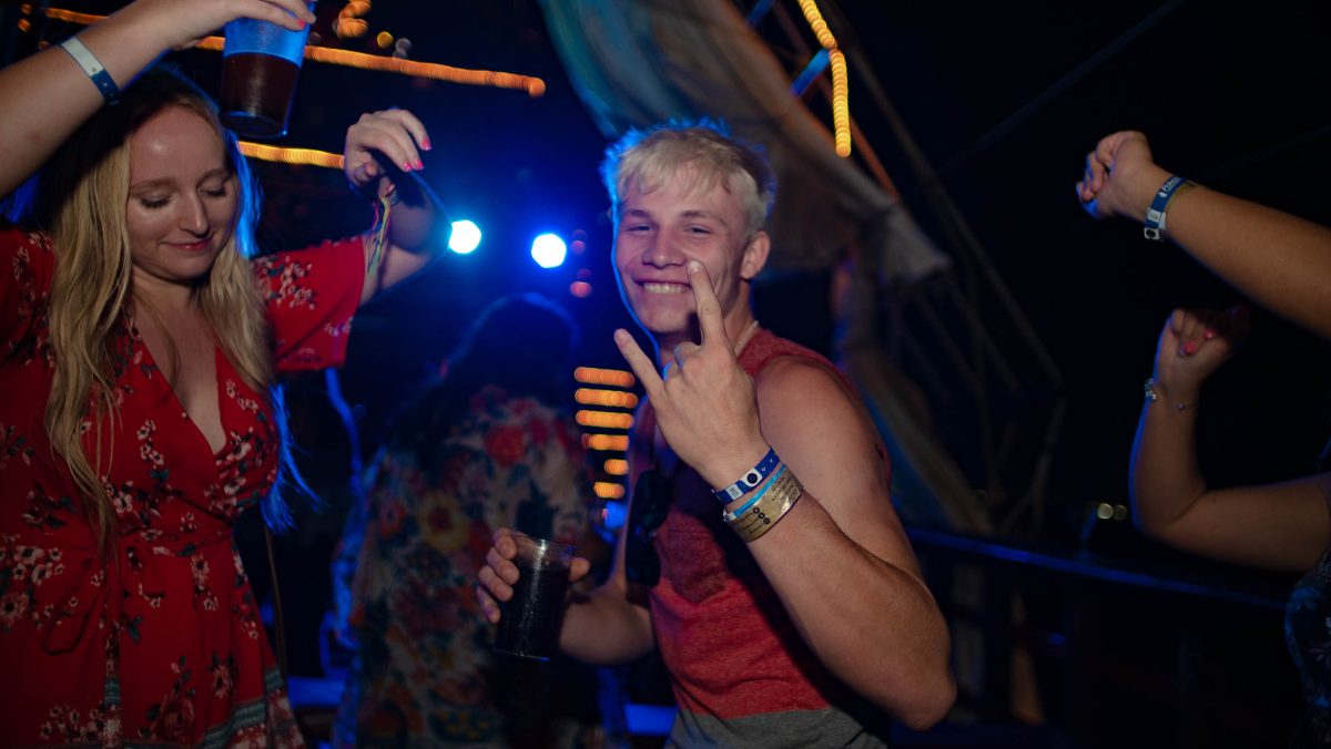 People dancing at a Jolly Roger Pirate Ship under colorful lights