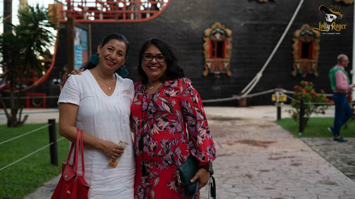 Two women standing together smiling at Jolly Roger Pirate Ship